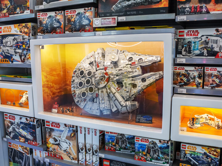 En modell av Star Wars Millennium Falcon i en glasmonter i Lego-butiken, med legobox-set på hyllorna