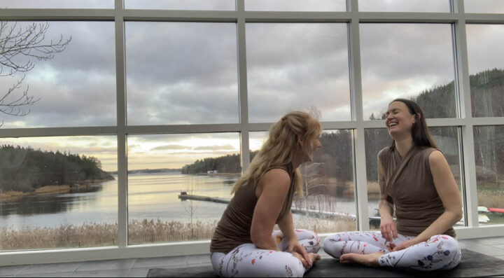 två kvinnor skrattar i yogadräkt