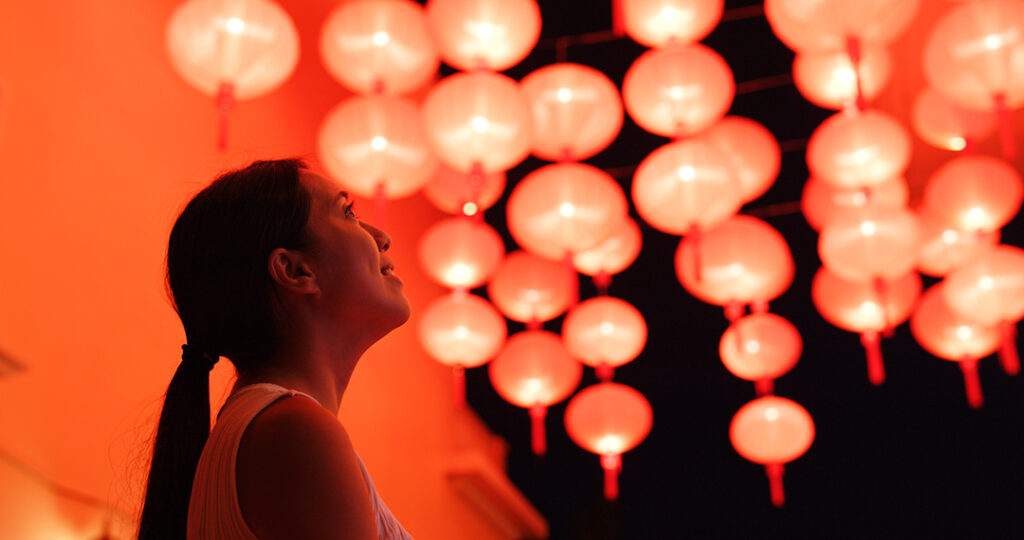  Kvinna tittar på den röda lyktor för kinesiska nyåret