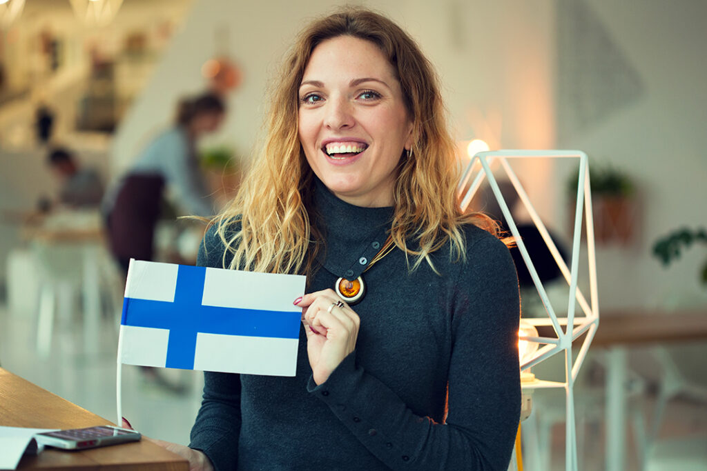 kvinna håller Finlands flagga
