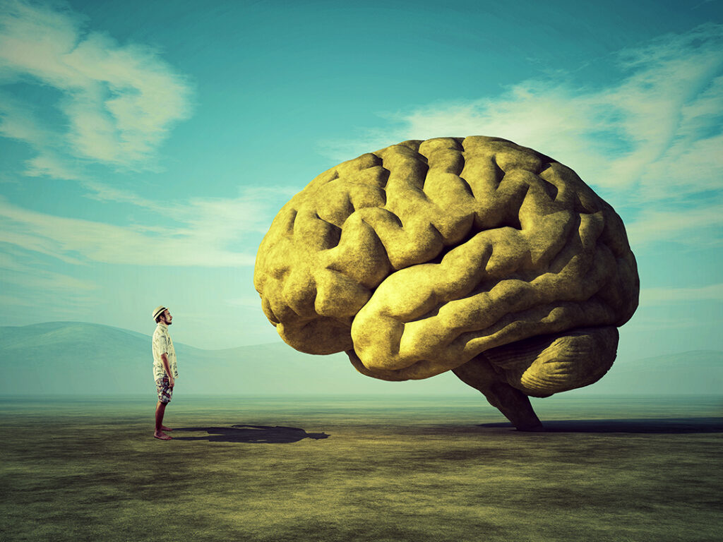 Mannen och den konceptuella bilden av en stor sten i form av den mänskliga hjärnan