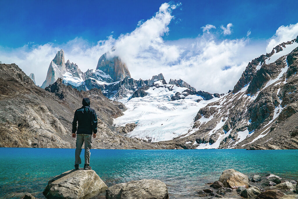 en man blickar över sjö och berg i patagonien