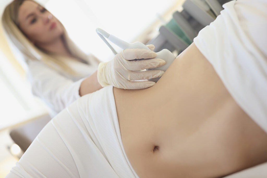 Läkare gör ultraljudsundersökning av njurar på en kvinna