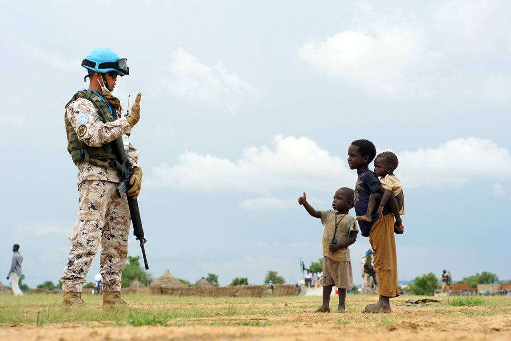 En FN-soldat hälsar på några barn i Syd Sudan