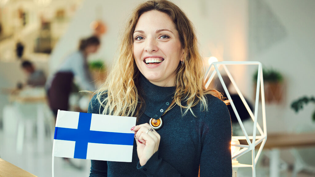 glad kvinna håller en finsk flagga