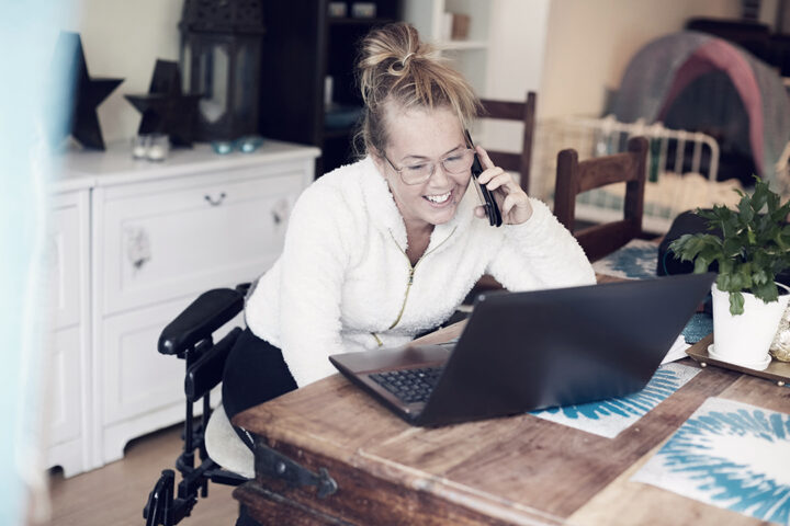 Ung kvinna med funktionshinder pratar i telefon