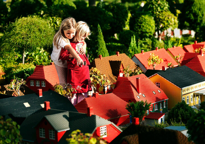 två barn tittar på små hus i Legoland