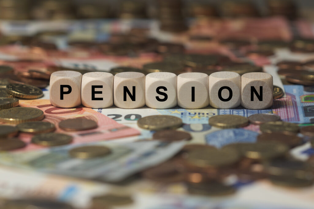 tärningar som bildar ordet pension som ligger på bädd av sedlar