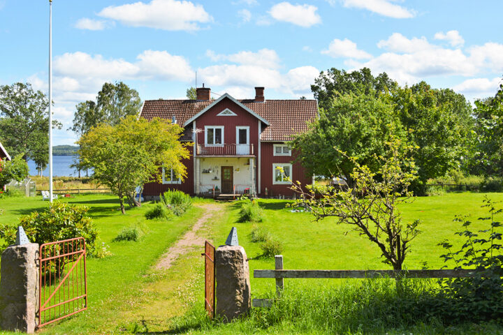 En traditionellt rödmålad villa med vita knutar. Solig sommardag