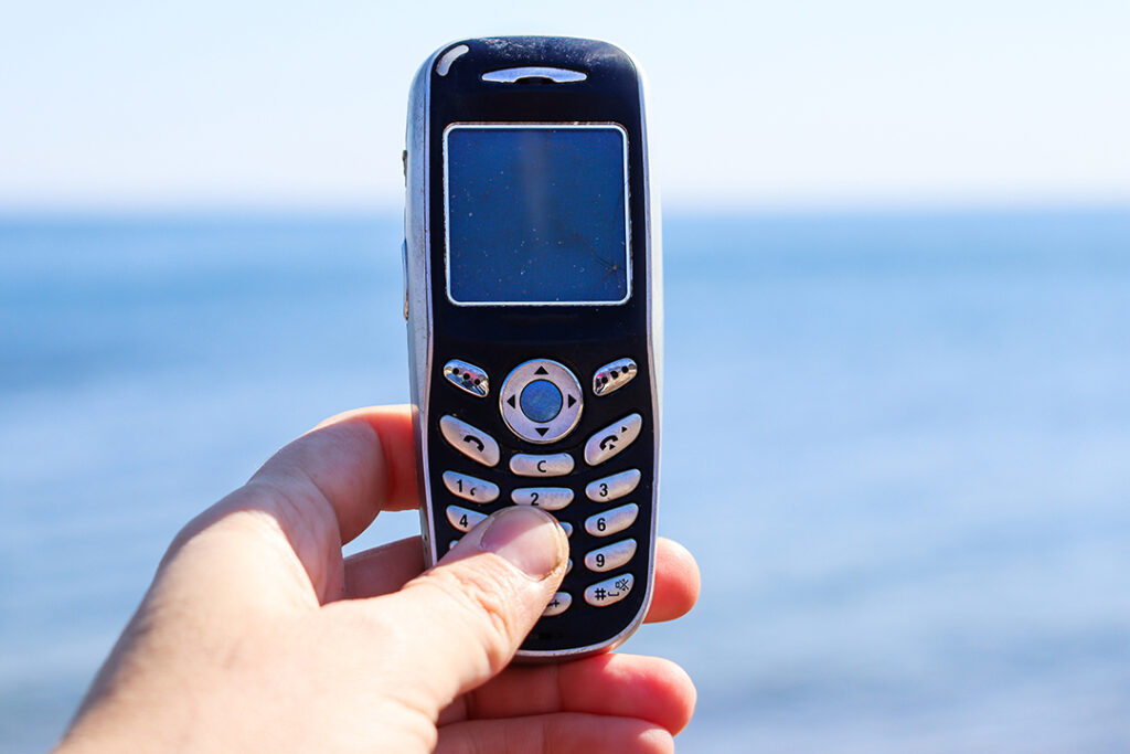 en hand som håller i en gammal mobiltelefon