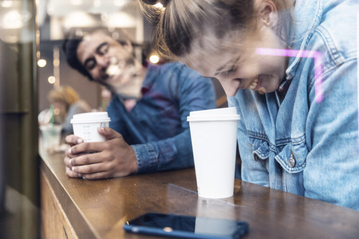 Vänner som har roligt tillsammans på ett kafé